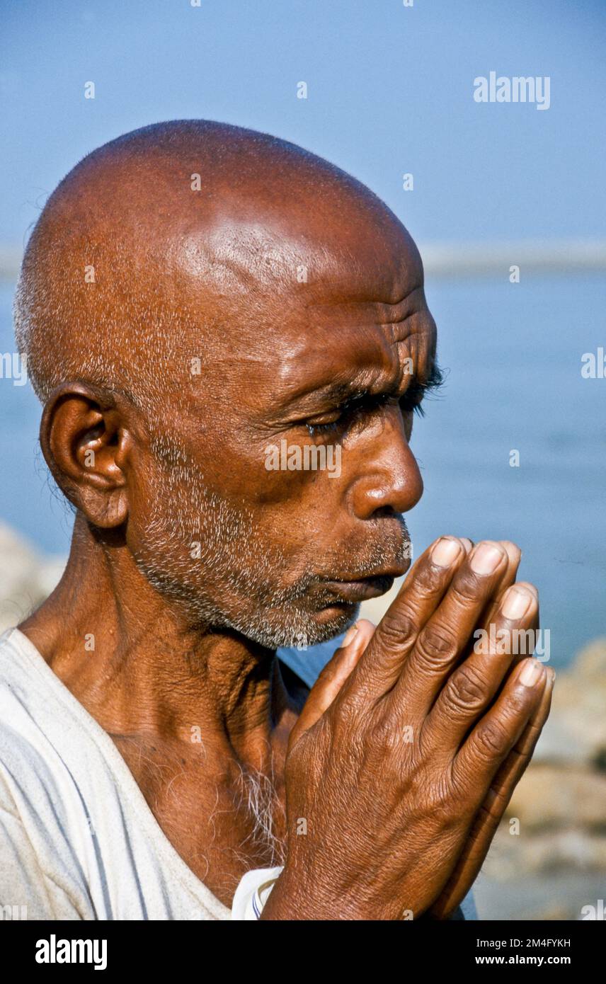 Pellegrino che prega verso l'acqua del fiume santo Narmada Foto Stock