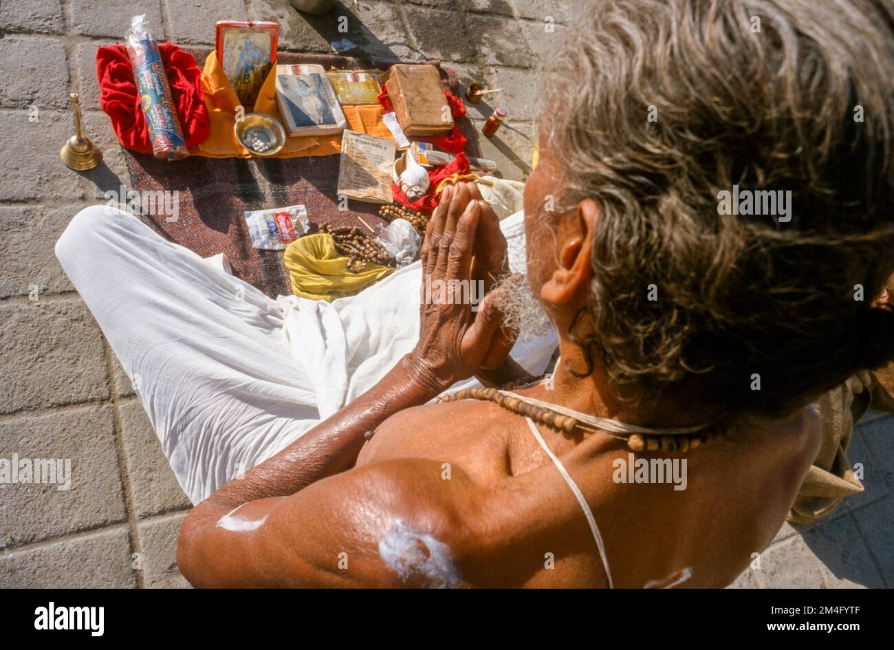 Sadhu, uomo santo, pregando ai suoi dei come parte della pooja del mattino. Haridwar Foto Stock