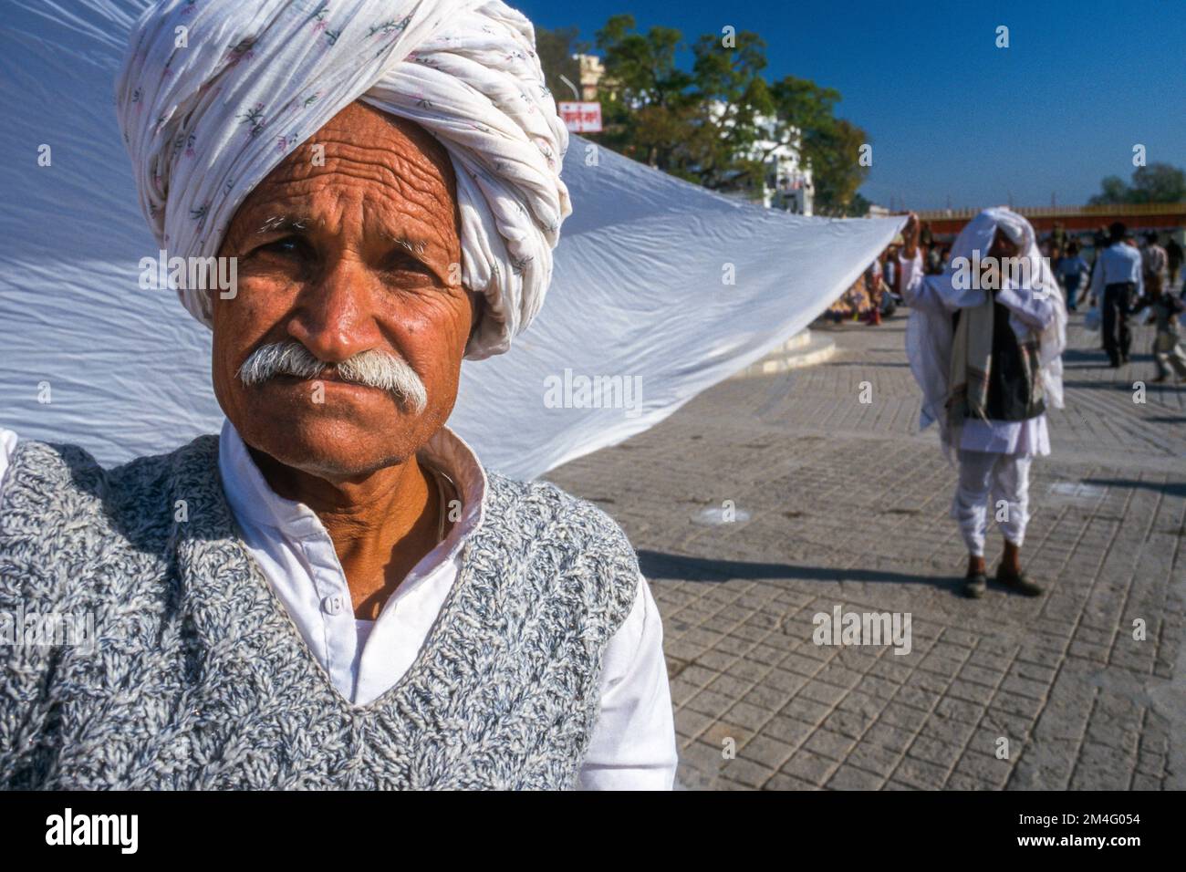 Due uomini che asciugano i Sari dei loro wifes dopo il loungdry. Haridwar Foto Stock