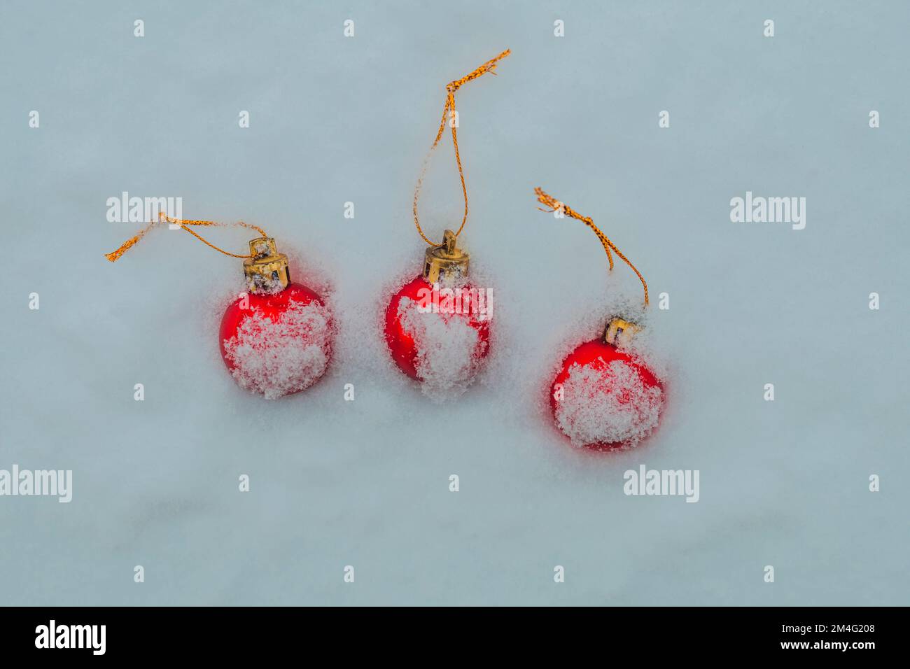 Natale baubles coperto di neve, tre baubles rossi Foto Stock