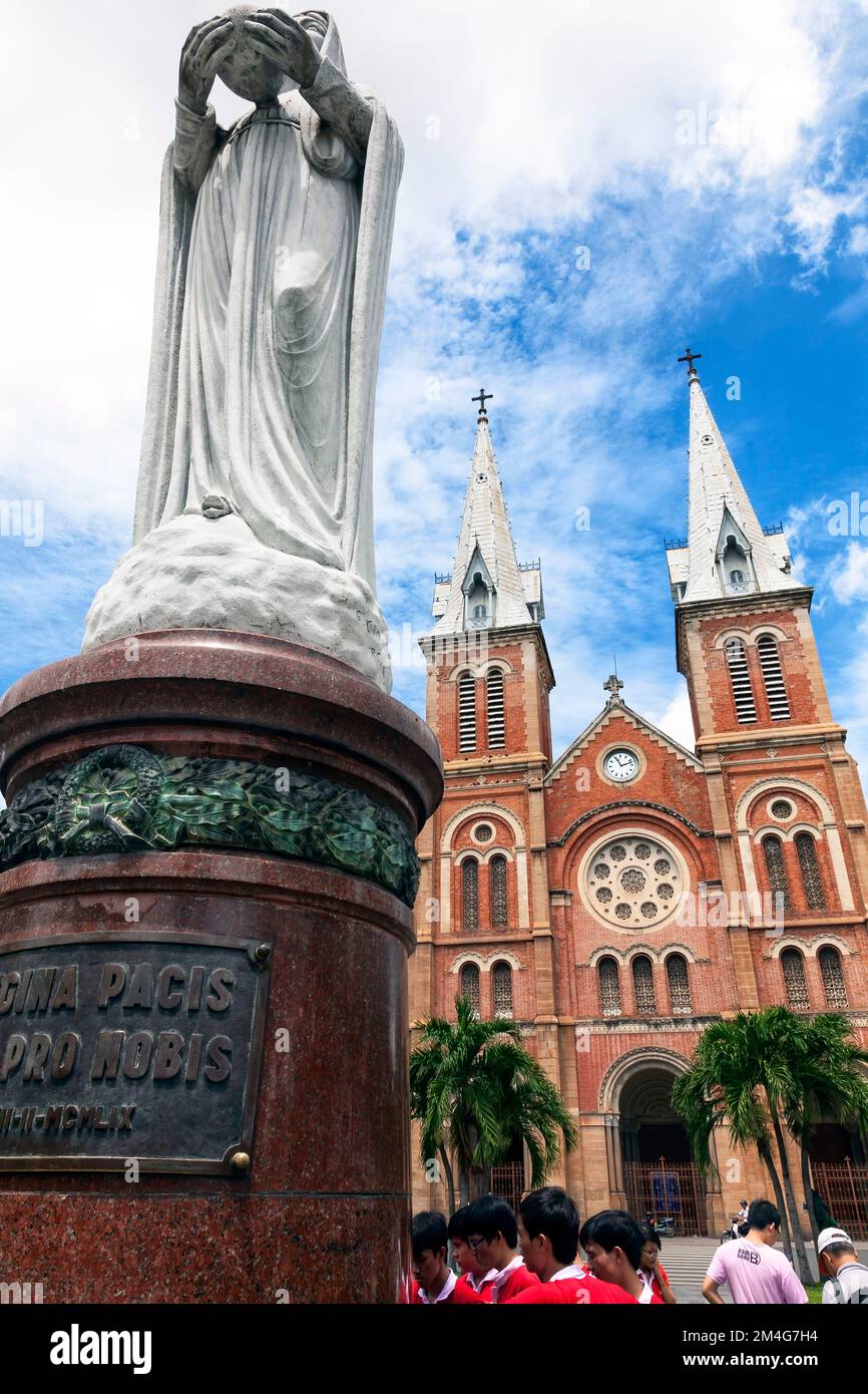 Turisti e statua, Cattedrale di Notre Dame, Saigon, Vietnam Foto Stock