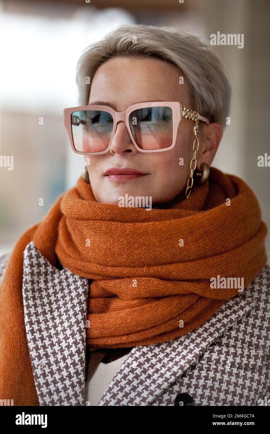 Donna ritratto capelli biondi corti in caldo maglia sciarpa ocra, giacca  bipetto e occhiali alla moda. Moda autunno o primavera, femmina f Foto  stock - Alamy