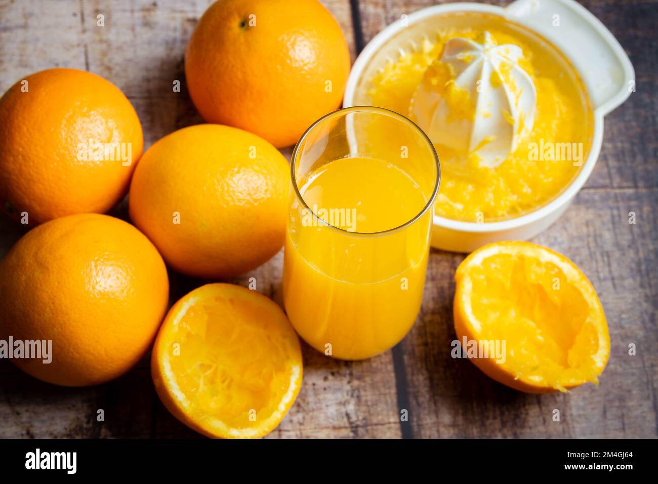 spremuta d'arancia fresca in un bicchiere su uno sfondo di legno Foto Stock