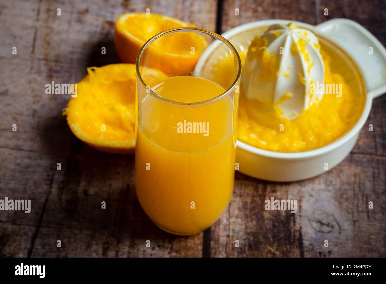 spremuta d'arancia fresca in un bicchiere su uno sfondo di legno Foto Stock
