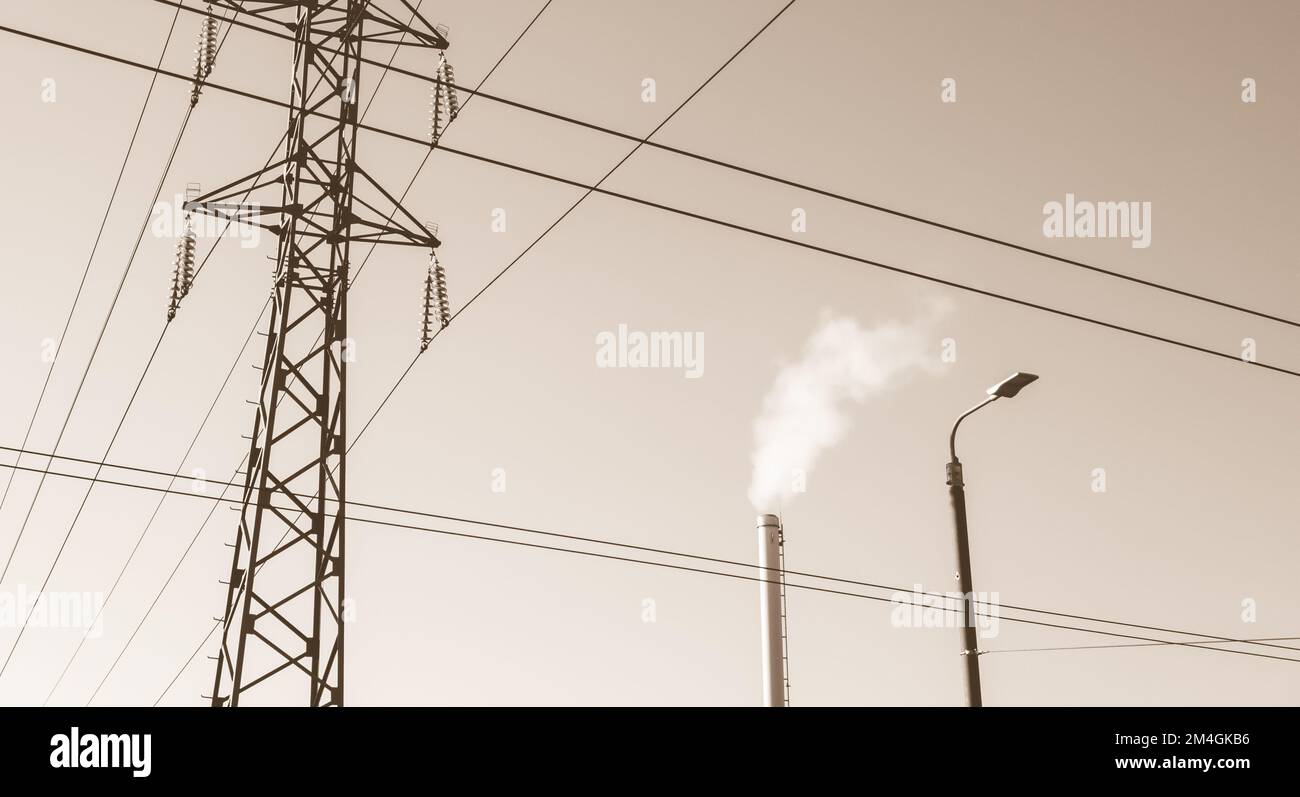 Camino di fabbrica con fumo. Tubo industriale. Torre della linea elettrica Foto Stock