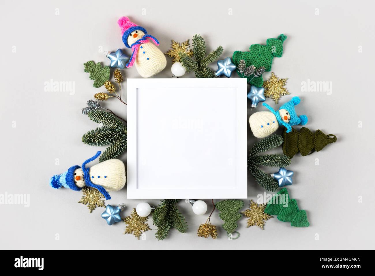 Composizione creativa di Natale con una cornice bianca per il testo e le congratulazioni per il nuovo anno e Natale. Pupazzi di neve a maglia e albero verde, Christma Foto Stock