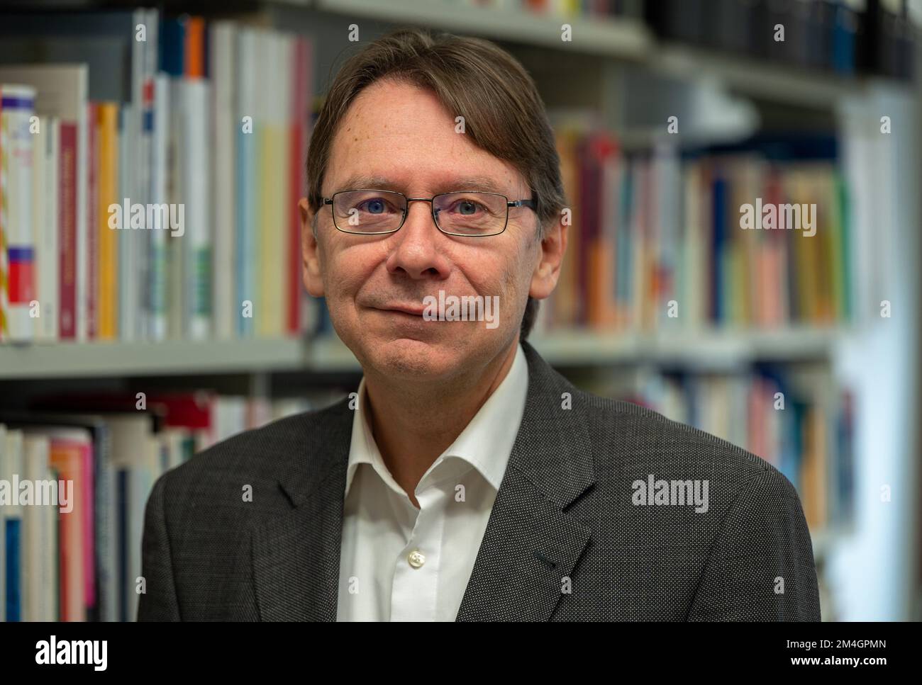 Treviri, Germania. 21st Dec, 2022. Uwe Jun, scienziato politico di Treviri, si trova di fronte a una libreria nel suo ufficio presso l'Università di Treviri. È anche direttore di un nuovo istituto per la democrazia e la ricerca di partito presso l'Università di Treviri. Credit: Harald Tittel/dpa/Alamy Live News Foto Stock