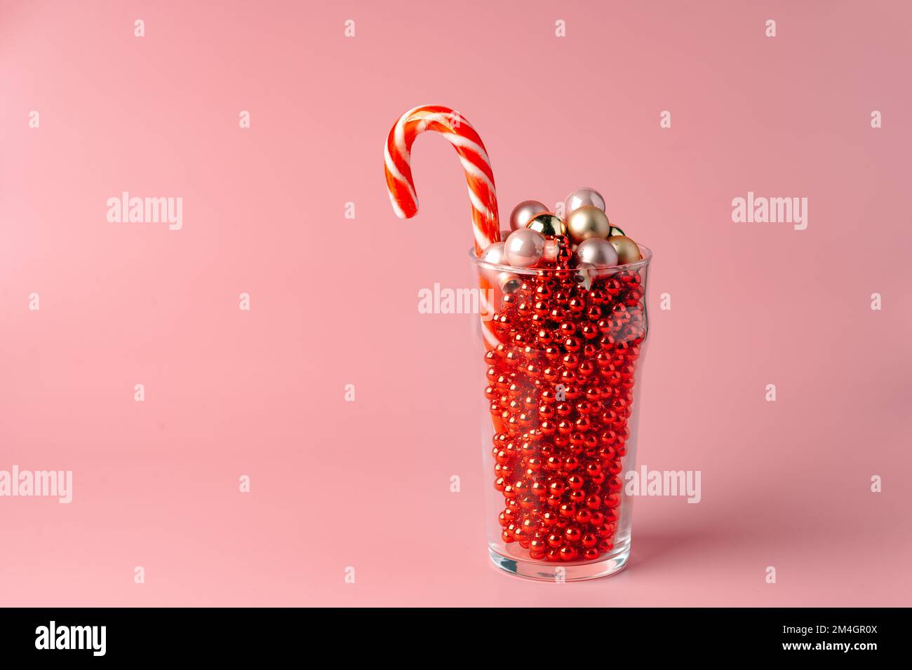 Studio shot di decorazioni natalizie in un vetro su sfondo rosa Foto Stock