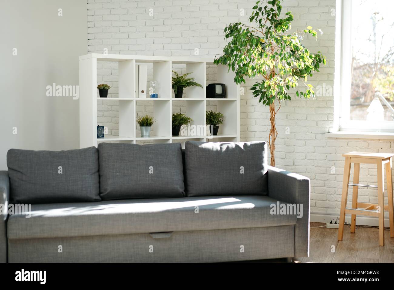 Divano grigio in un semplice soggiorno interno Foto Stock