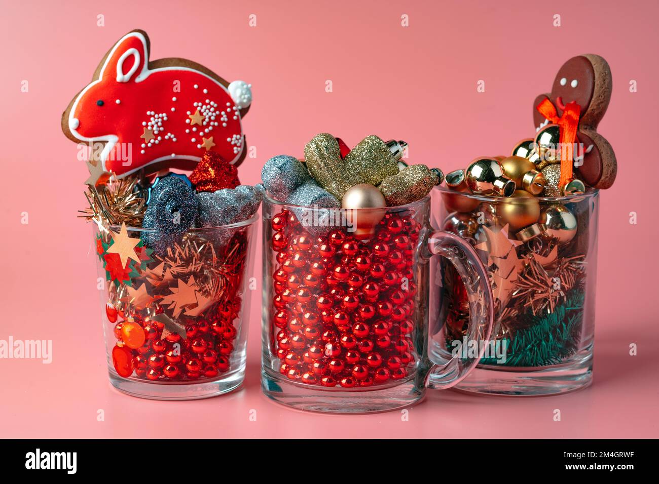 Vetro con decorazioni natalizie su sfondo rosa pastello Foto Stock
