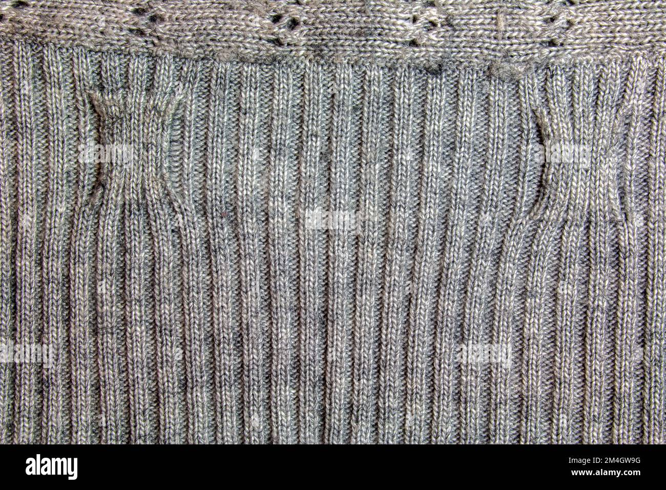 Sfondo felpa lavorato a mano grigio. La texture della superficie della maglia di lana di filato, primo piano. Immagine per lo sfondo. Carpe di lana Foto Stock