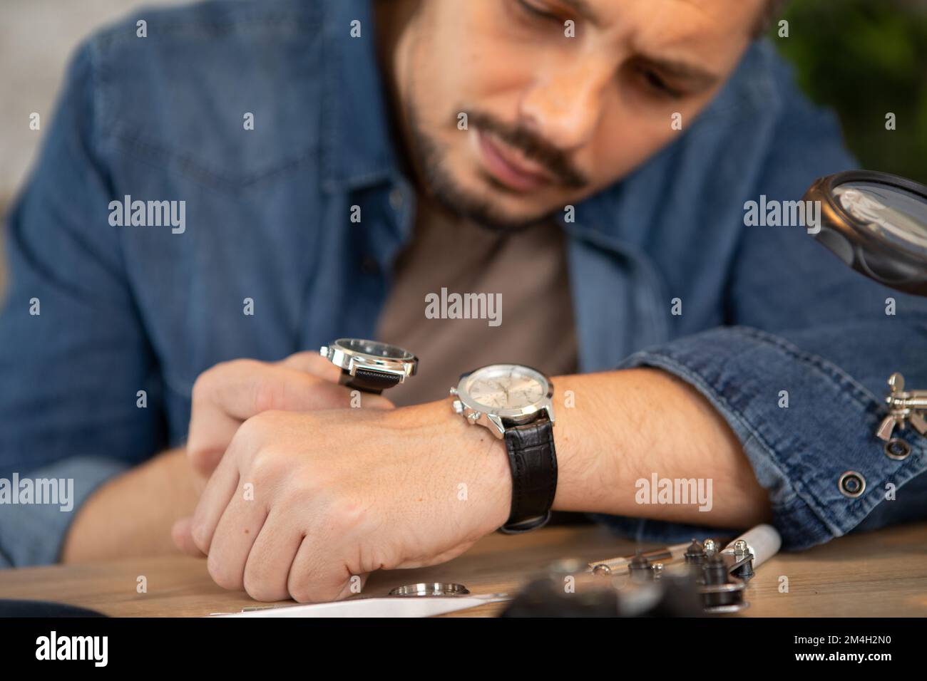 Orologiaio con lente di ingrandimento assemblaggio di un orologio da polso,  fabbricazione d'horlogerie Voutilainen, Motiers, Svizzera Foto stock - Alamy