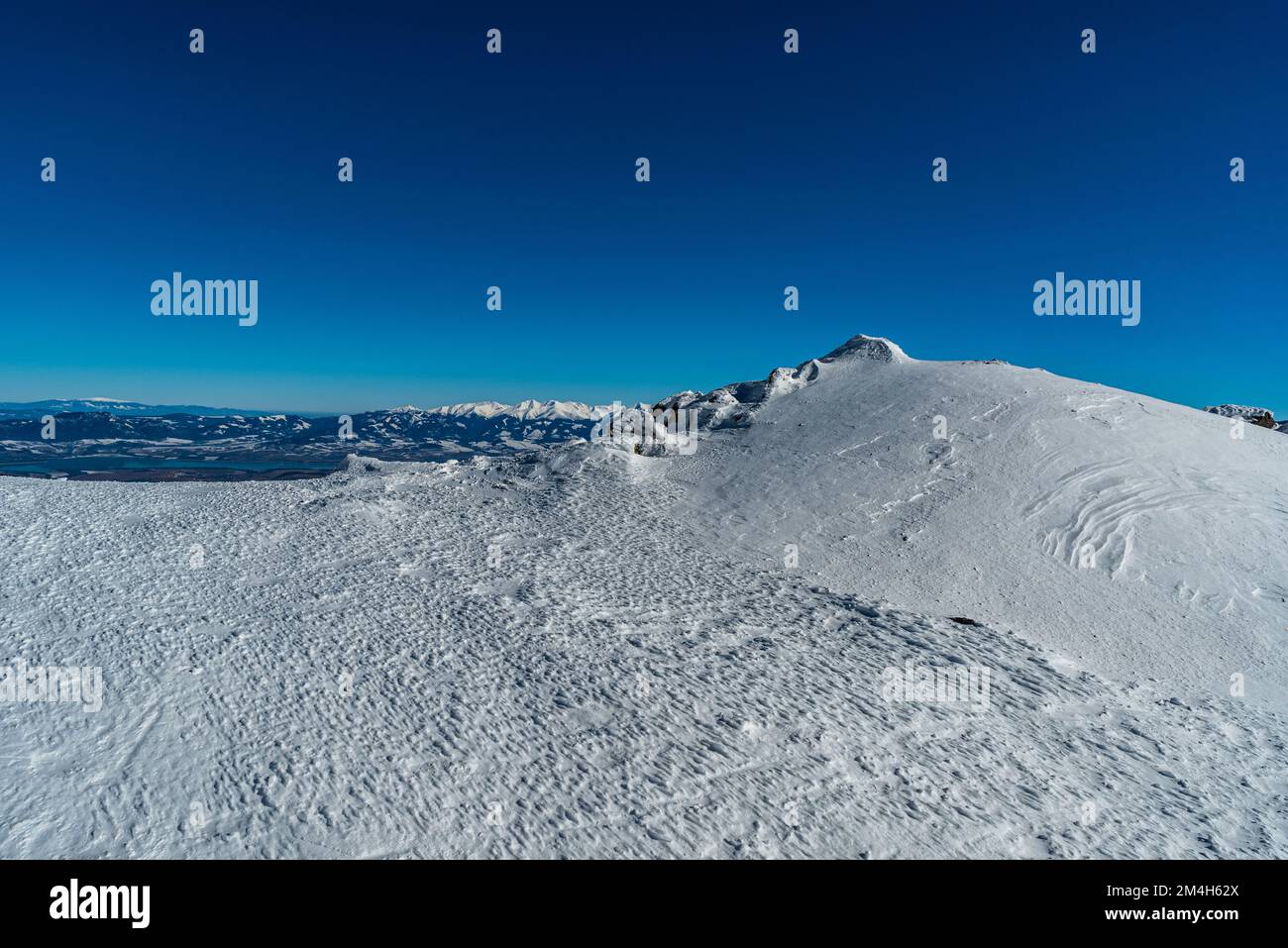 Vista a Babia Hora, Chocske vrchy, Liptovska Mara e parte dei Tatra occidentali dal sentiero escursionistico che costeggiano la collina di Chabenec in inverno bassa montagna Tatra Foto Stock