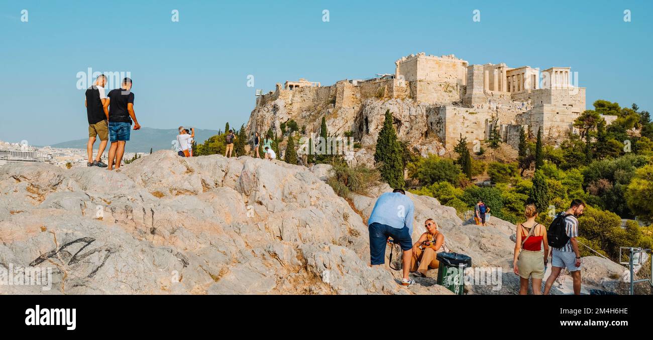 Atene, Grecia - 29 agosto 2022: Alcune persone in cima ad una collina cercano il posto migliore per scattare foto dell'Acropoli di Atene, in Grecia, io Foto Stock