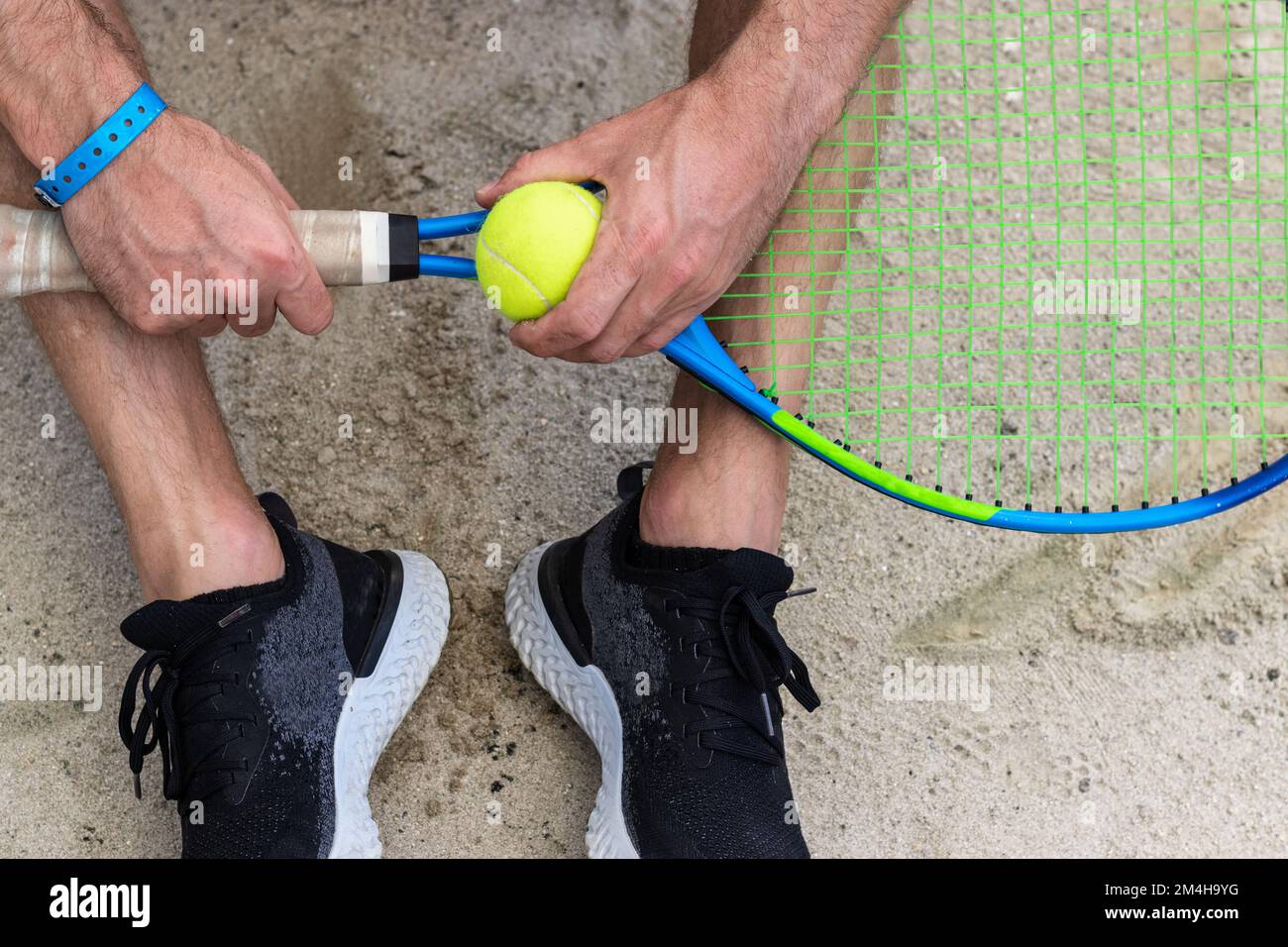 Racchetta da tennis e palla da tennis in mano all'uomo. Foto Stock