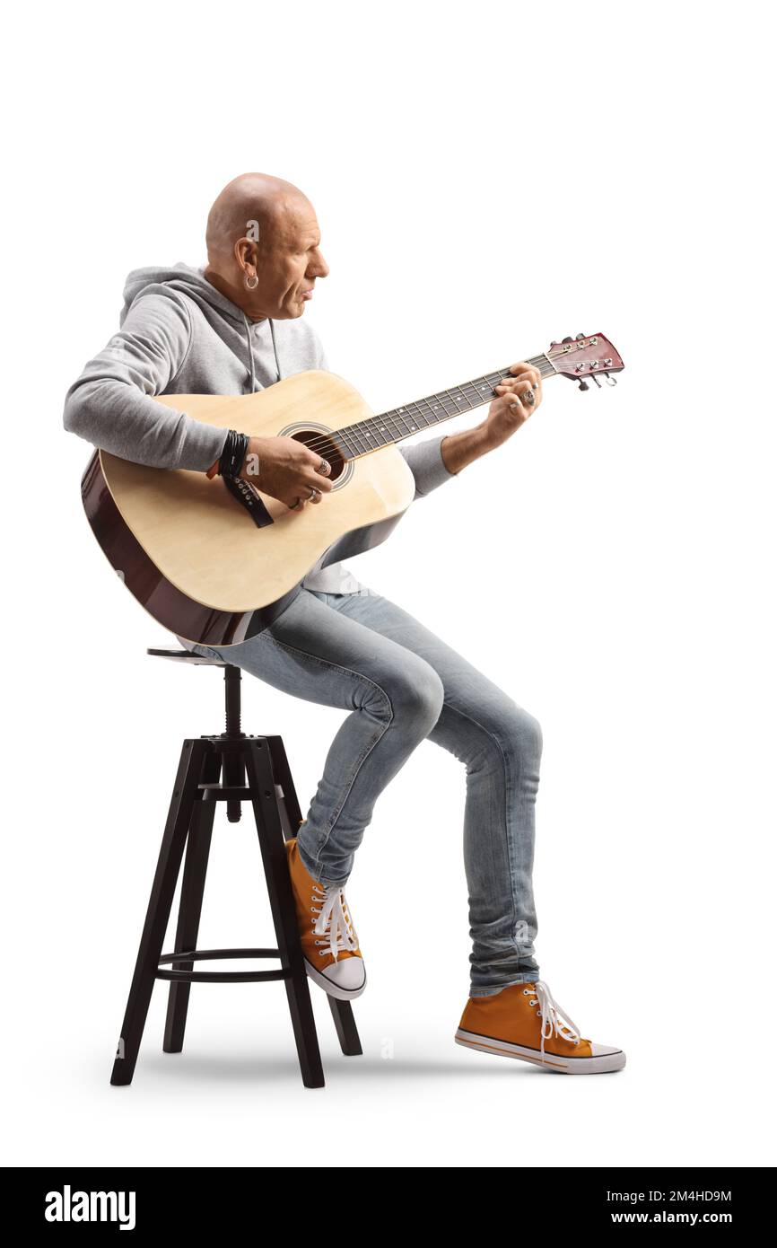 Profilo a tutta lunghezza di un calvo che suona una chitarra acustica seduto su una sedia isolata su sfondo bianco Foto Stock Profilo a tutta lunghezza di un calvo che suona una chitarra acustica seduto su una sedia isolata su sfondo bianco Foto Stock