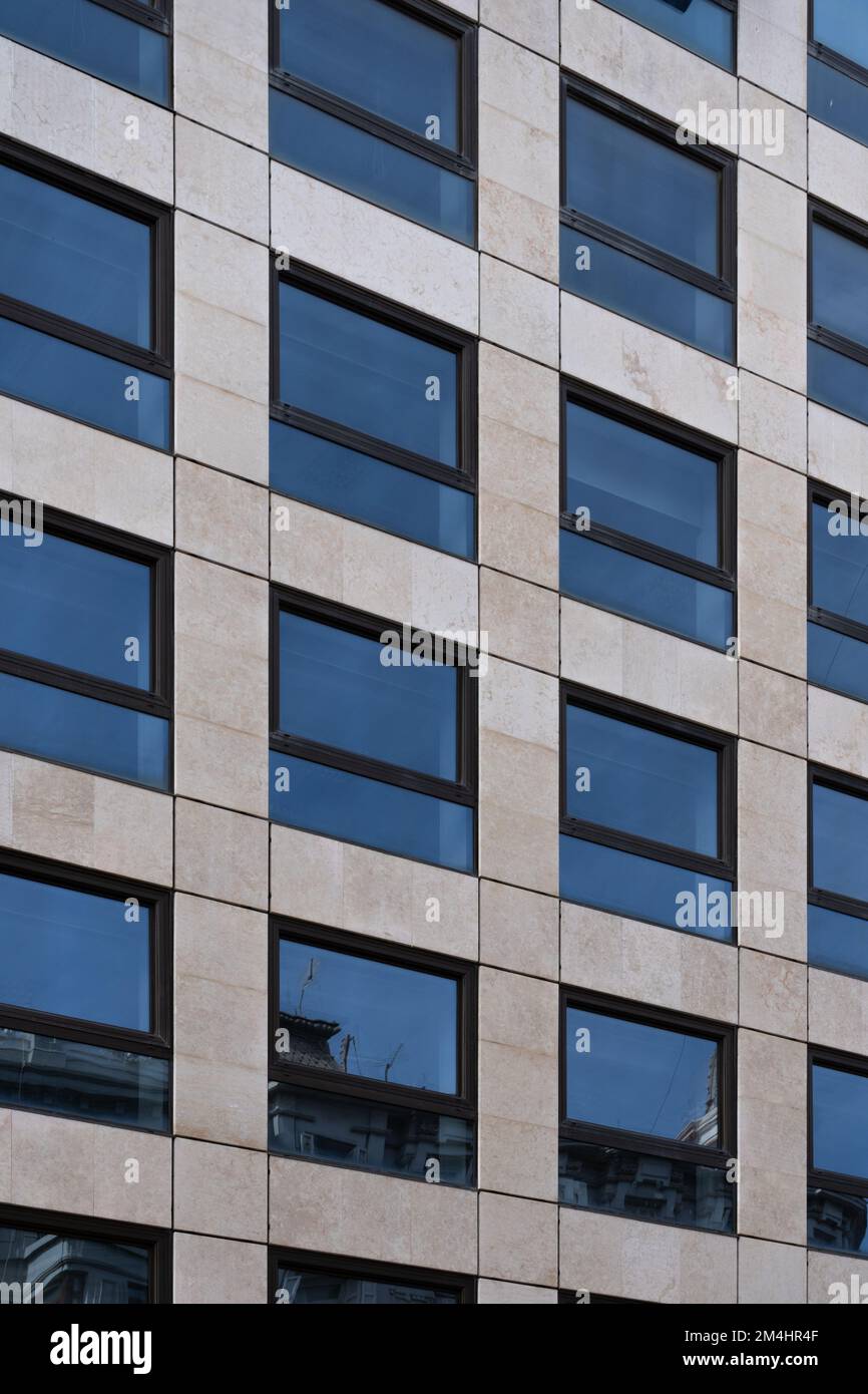 Prospettiva di un edificio dalla facciata moderna con finestre che creano un motivo. Concetto di background dell'architettura Foto Stock