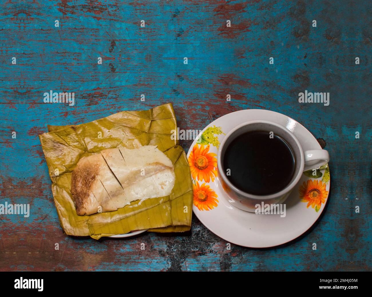 Tradizionale Tamal Pisque Stuffed con una tazza di caffè servita su un tavolo di legno, cibo tipico dell'America Centrale Tamal Stuffed Pisque, tamale Stuffed con Foto Stock