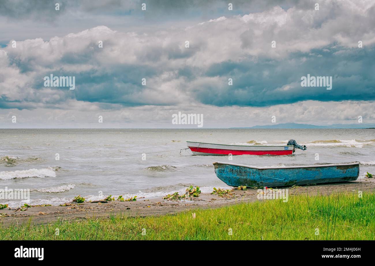 Due barche da pesca in legno sulla riva di un bellissimo lago. Due barche da pesca parcheggiate sulla riva di un lago, Nicaragua. Concetto di due barche da pesca Foto Stock