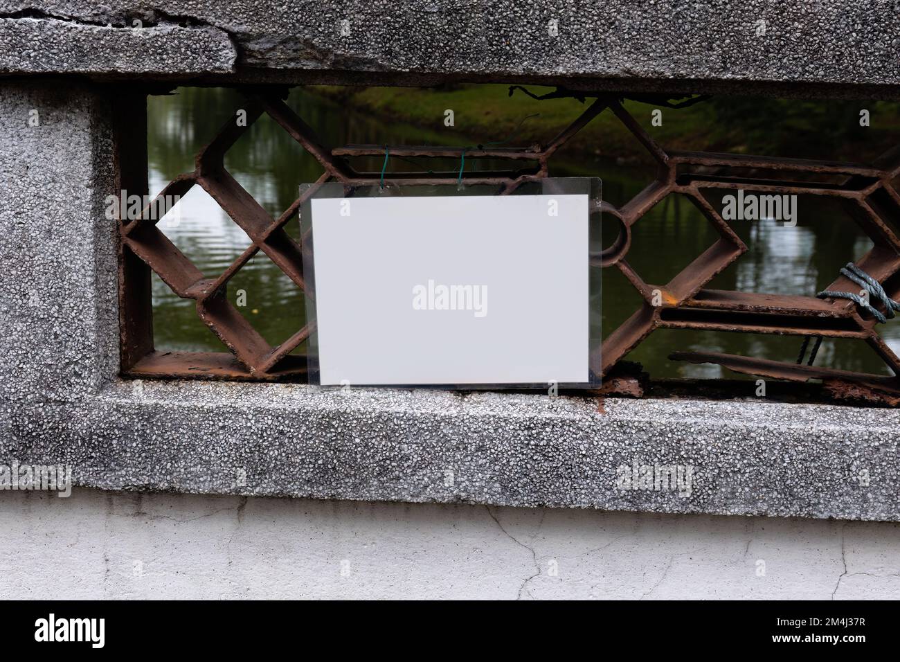 Un cartello bianco laminato vuoto attaccato ad un ponte Foto Stock