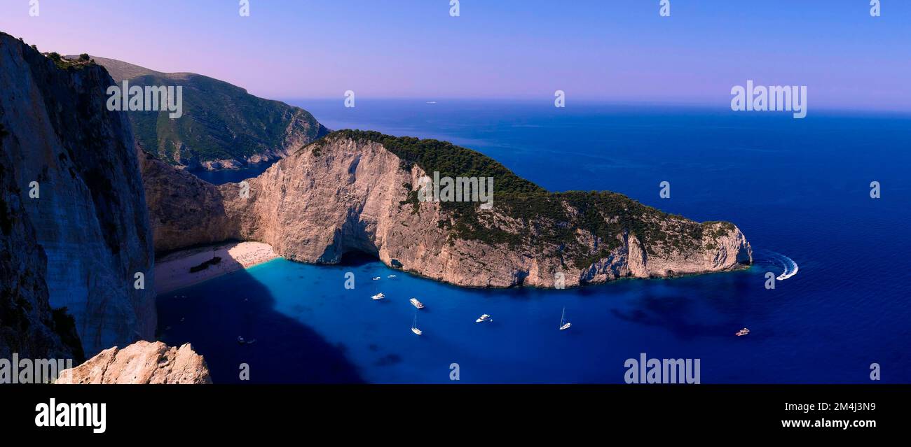 Paralia Navagio, Shipwreck Beach, foto panoramica, scogliera rocciosa, naufragio MV Panagiotis, barche da escursione, mare cristallino blu e turchese Foto Stock