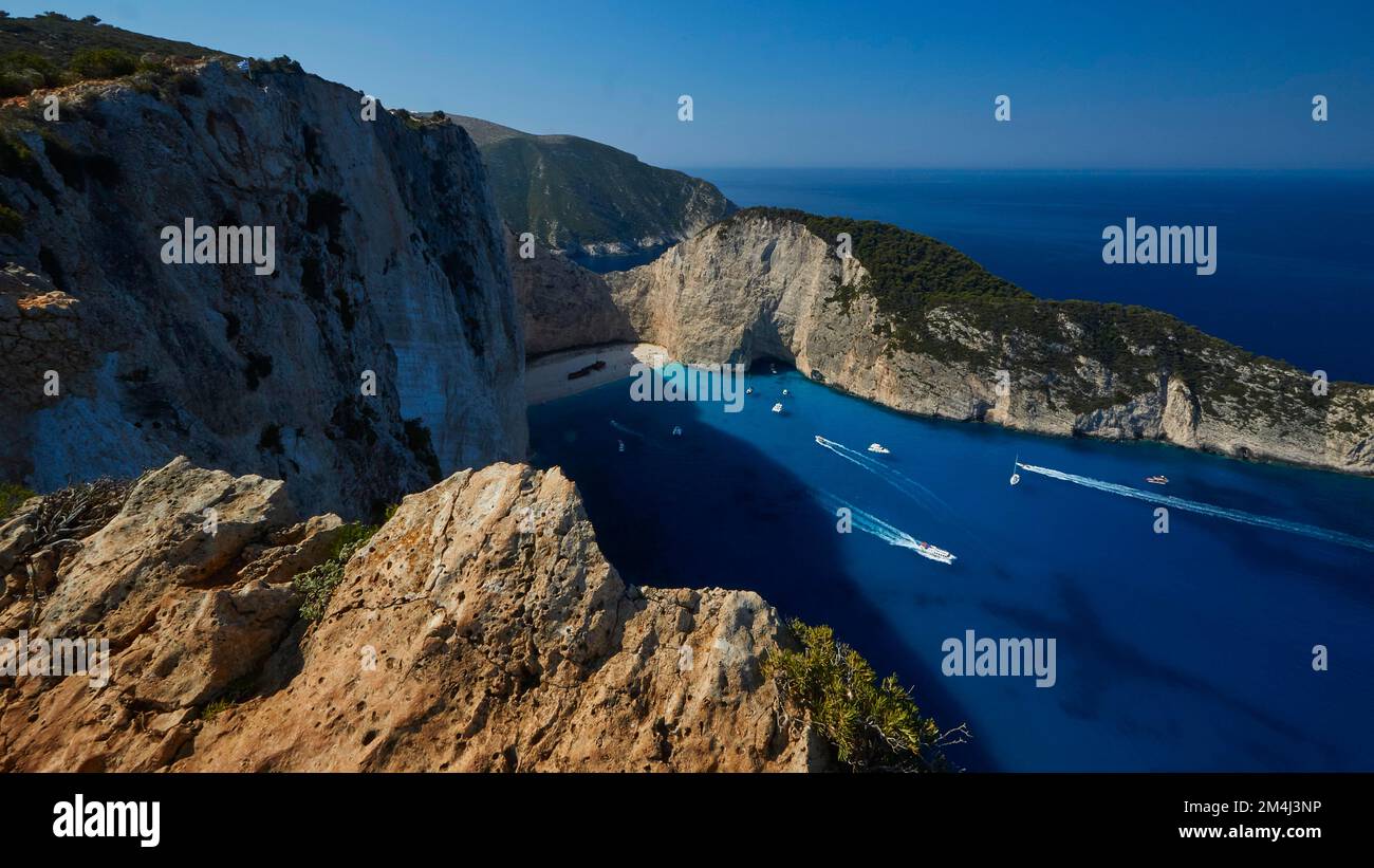 Paralia Navagio, Shipwreck Beach, scogliera rocciosa, naufragio MV Panagiotis, barche da escursione, mare cristallino blu e turchese, cielo blu senza nuvole Foto Stock