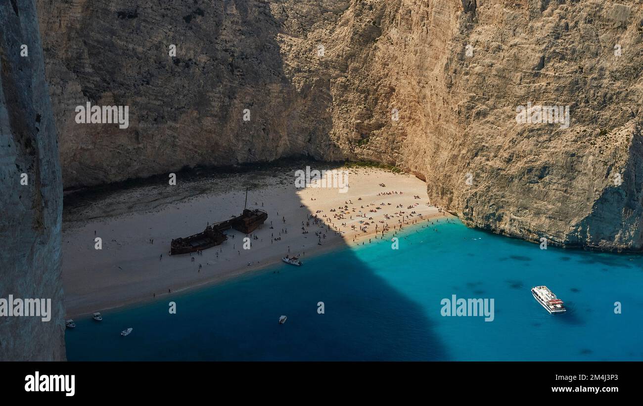 Paralia Navagio, Shipwreck Beach, naufragio MV Panagiotis, molti turisti sulla spiaggia, scogliera rocciosa, barche da escursione, blu e turchese cristallino Foto Stock
