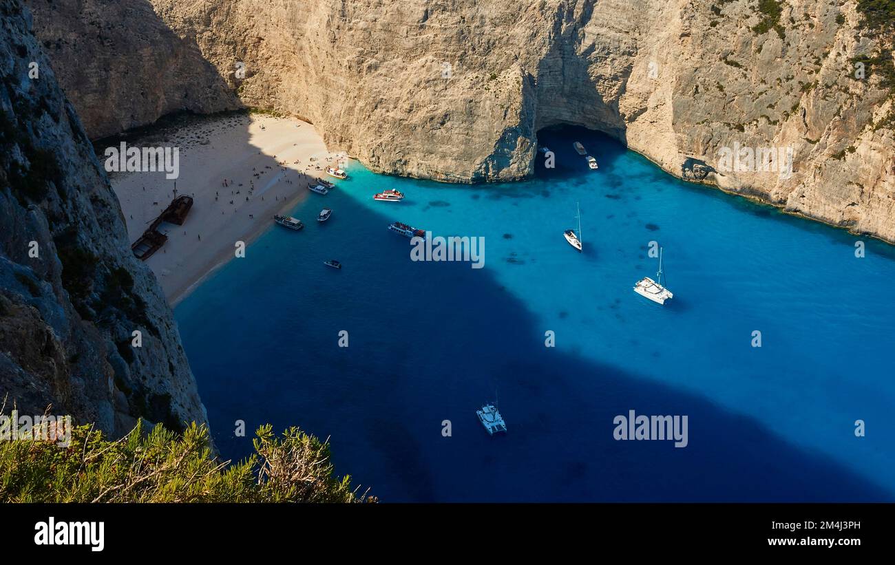 Paralia Navagio, Shipwreck Beach, scogliera rocciosa, naufragio MV Panagiotis, barche da escursione, barca a vela, catamarano, mare cristallino blu e turchese Foto Stock