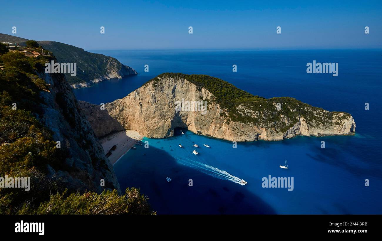 Paralia Navagio, Shipwreck Beach, scogliera rocciosa, naufragio MV Panagiotis, barche da escursione, mare cristallino blu e turchese, cielo blu senza nuvole Foto Stock