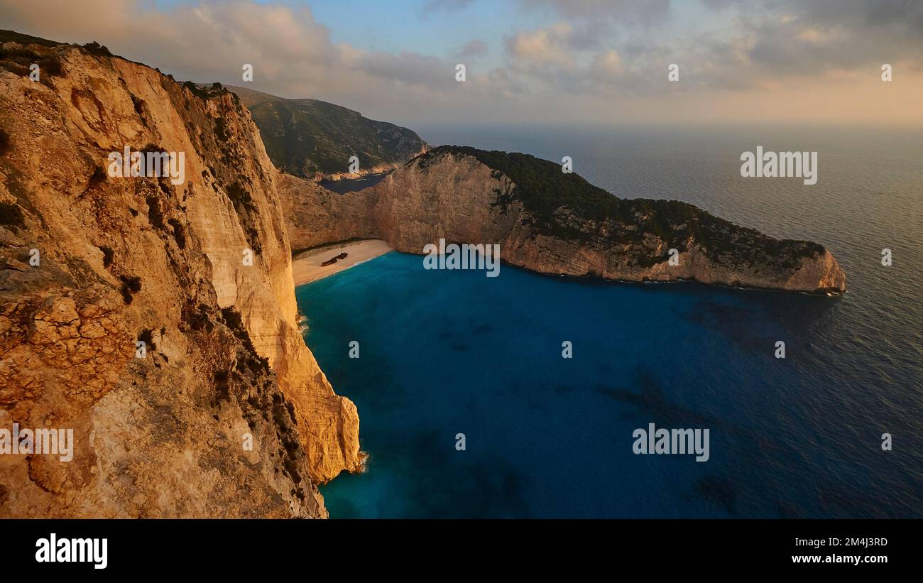Paralia Navagio, Shipwreck Beach, naufragio MV Panagiotis, inverno, scogliera rocciosa, cielo nuvoloso, spiaggia deserta, mare cristallino blu e turchese Foto Stock