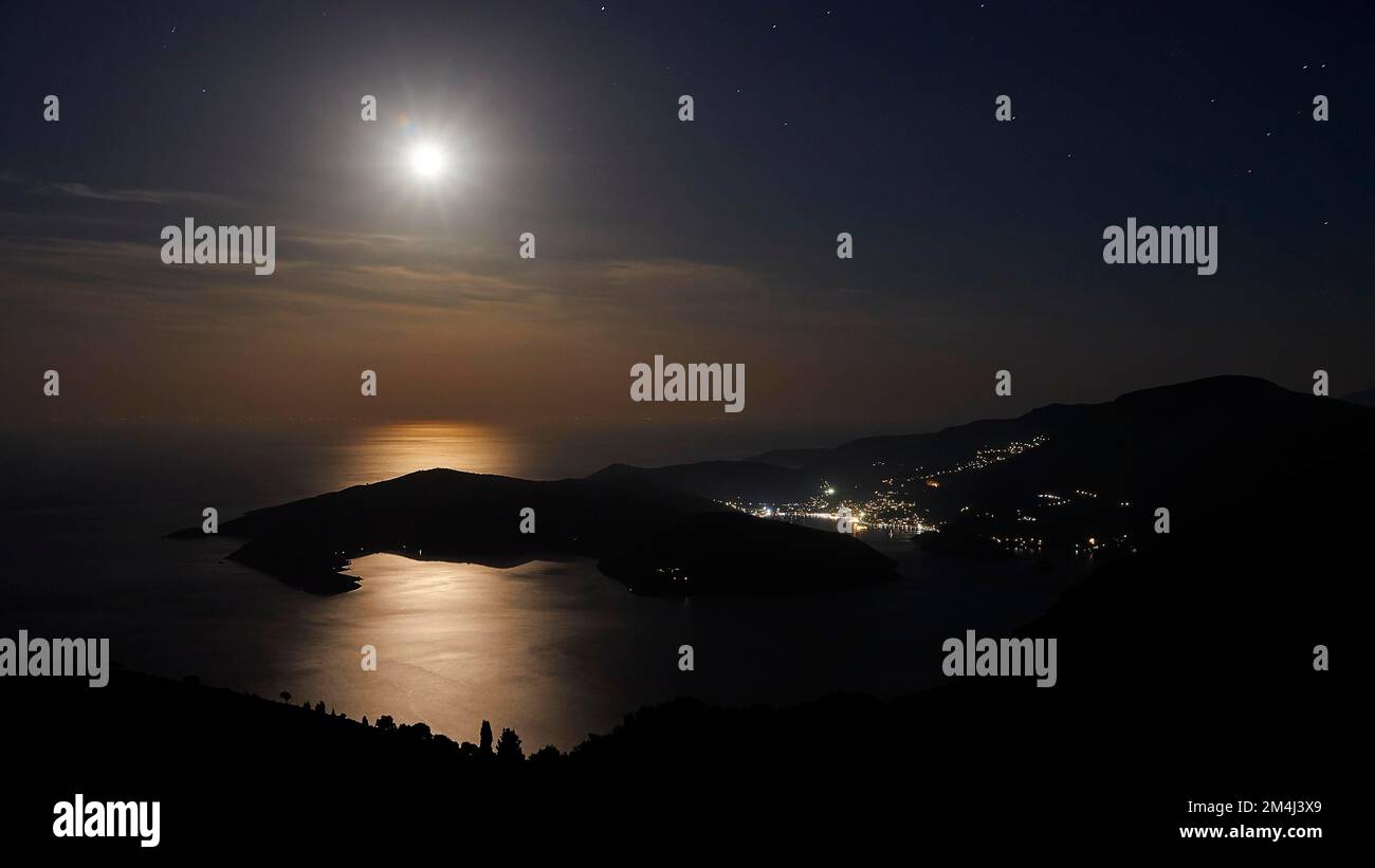 Foto notturna, luce della luna piena, luna piena come stella, riflessi della luna sull'acqua, baia di Molos, città principale, Vathi, isola di Ithaca, Isole IONIE Foto Stock