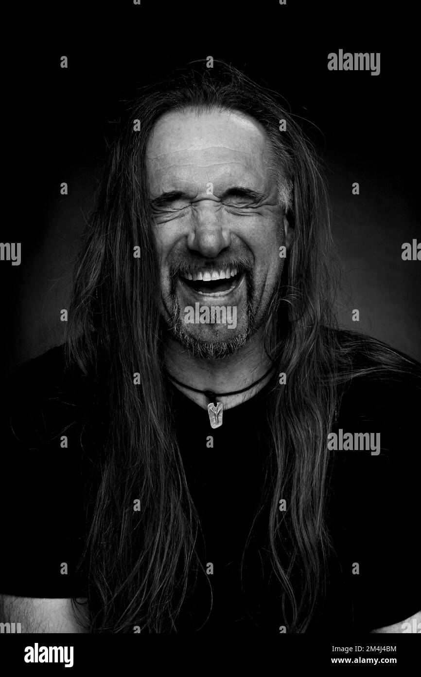 Uomo con capelli lunghi ridendo, foto in bianco e nero Foto Stock