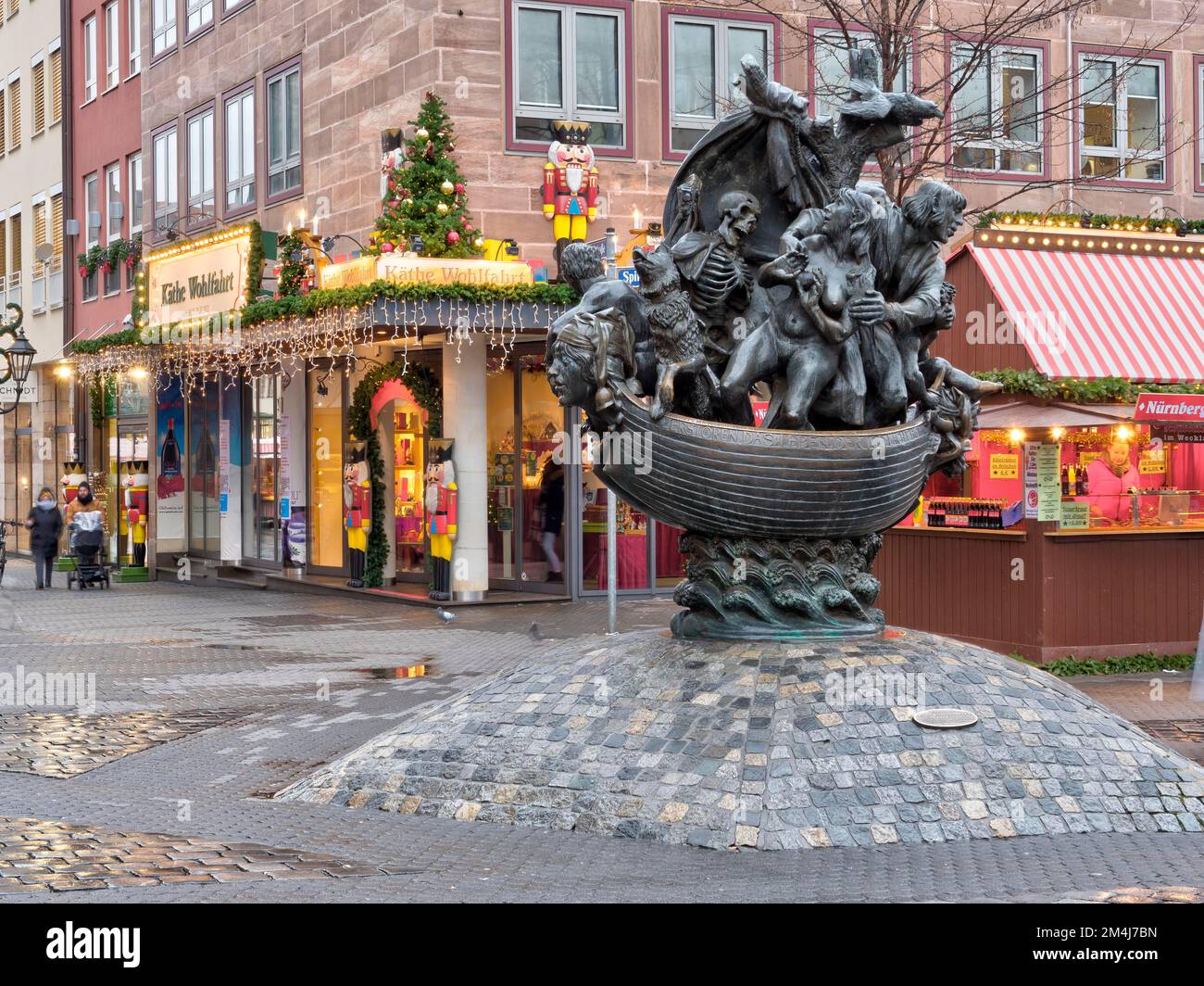 Fontana scultura Narrenschiffbrunnen in Plobenhofstrasse e decorazioni natalizie sullo sfondo dell'edificio, Norimberga, Franconia media Foto Stock