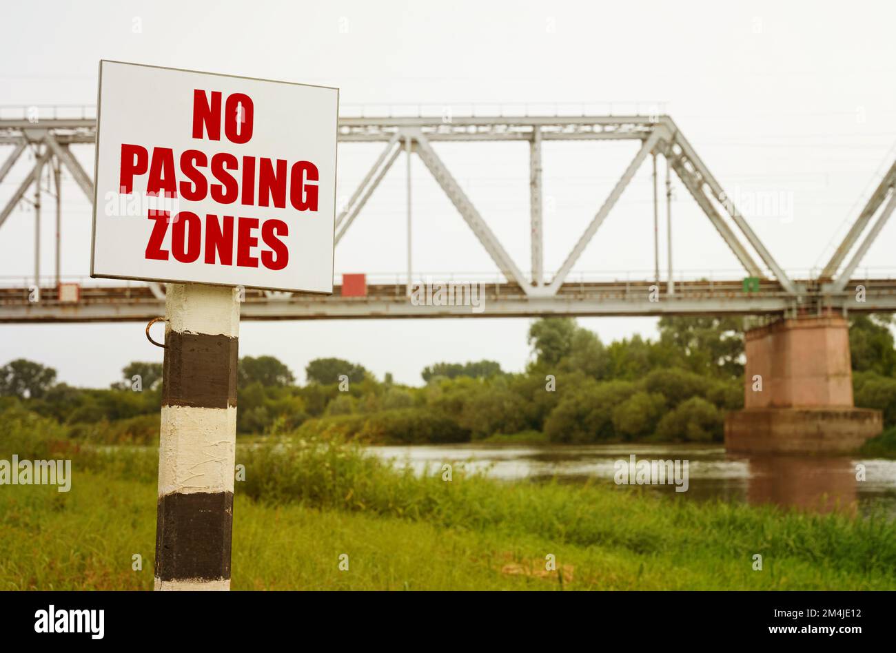Sullo sfondo del ponte ferroviario si trova un cartello con l'iscrizione "zone non passanti". Foto Stock