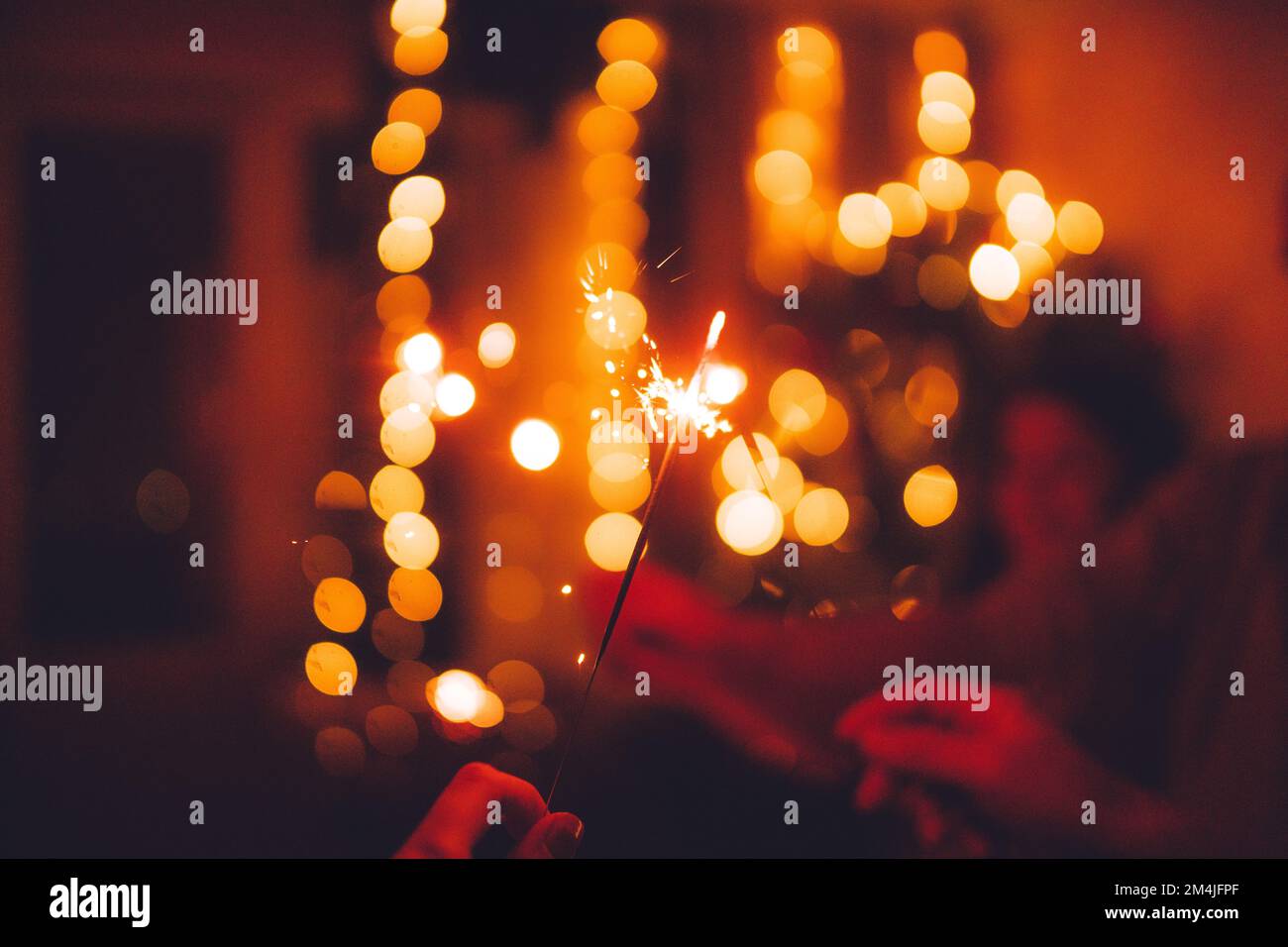 Brillante Natale festivo o Capodanno scintillante in mano tonificante, gruppo di amici che festeggiano insieme. Foto Stock