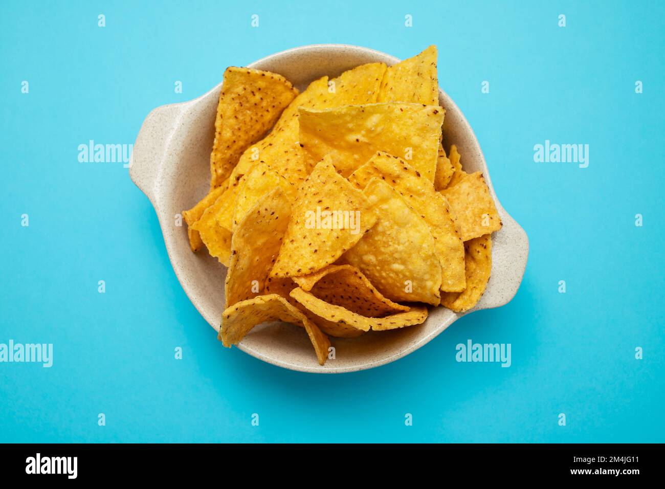 Poche patatine di nachos messicane in una piccola ciotola blu Foto Stock