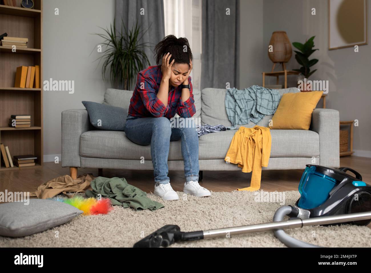 Depressione, disperazione da disordine, molti lavorano. Stanco triste millennial signora nera sedersi sul divano tenendo la testa Foto Stock