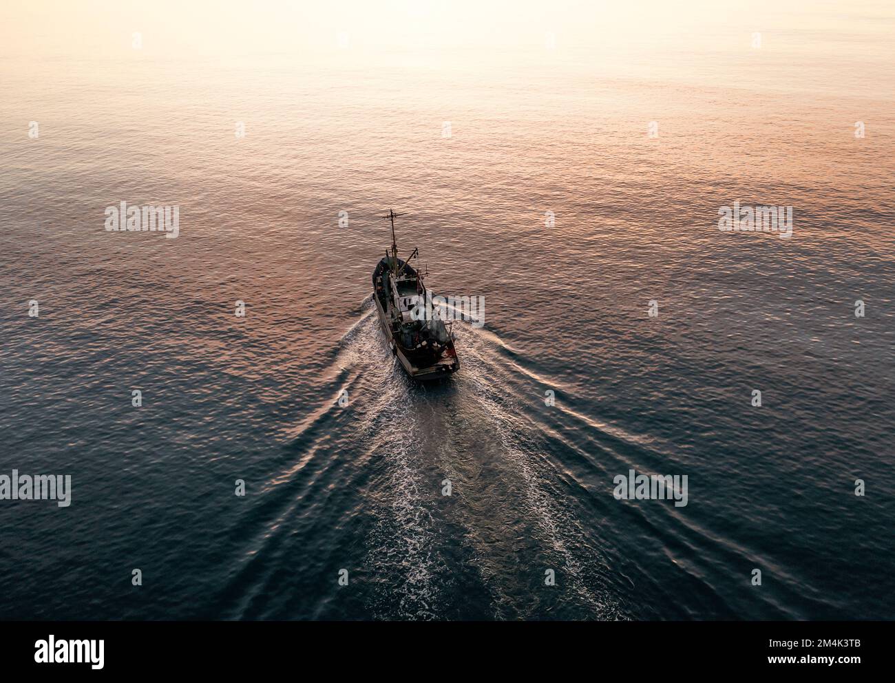 Piccola barca da pesca cattura pesci, vista aerea dall'alto dal drone. Pesca commerciale industriale. Foto Stock