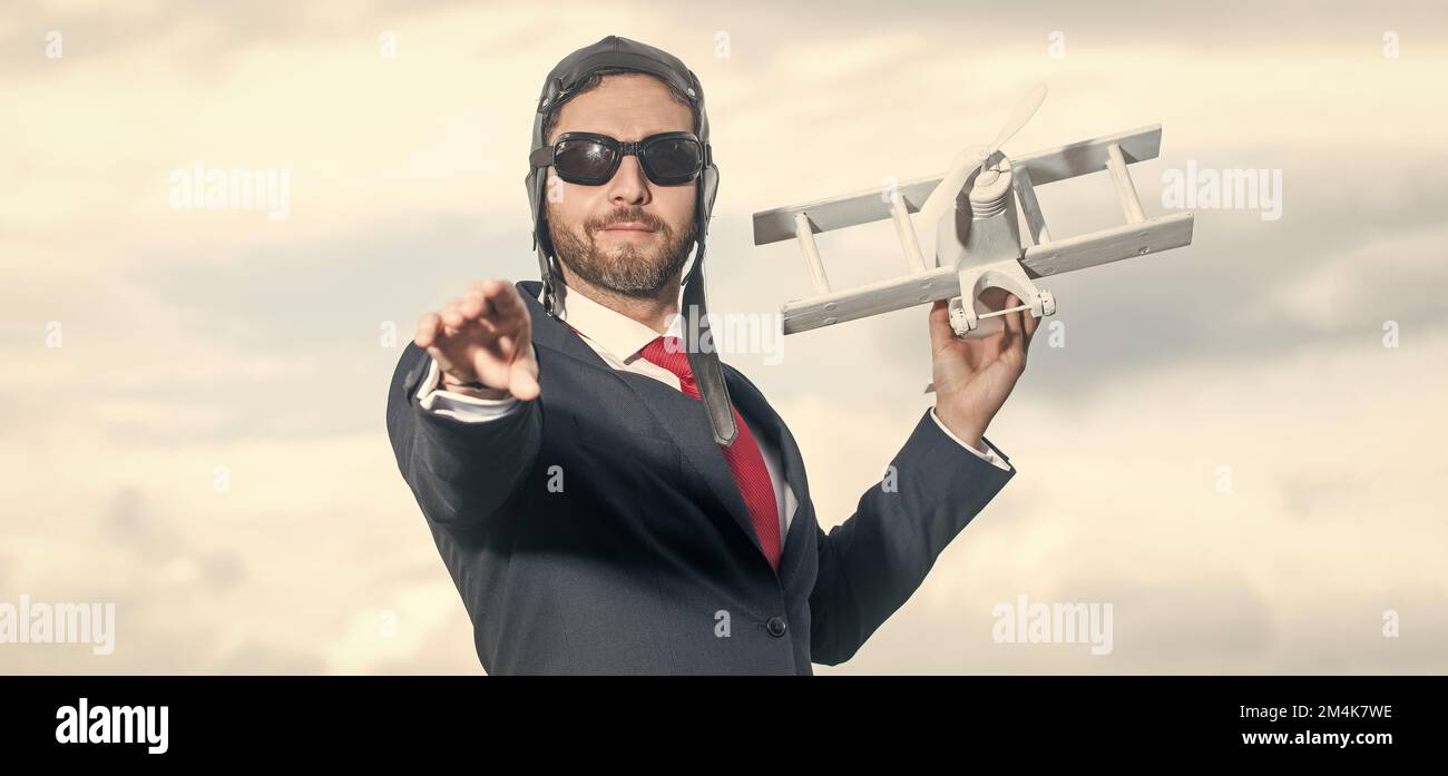 uomo d'affari in tuta e cappello pilota lancio aereo giocattolo. sfida Foto Stock