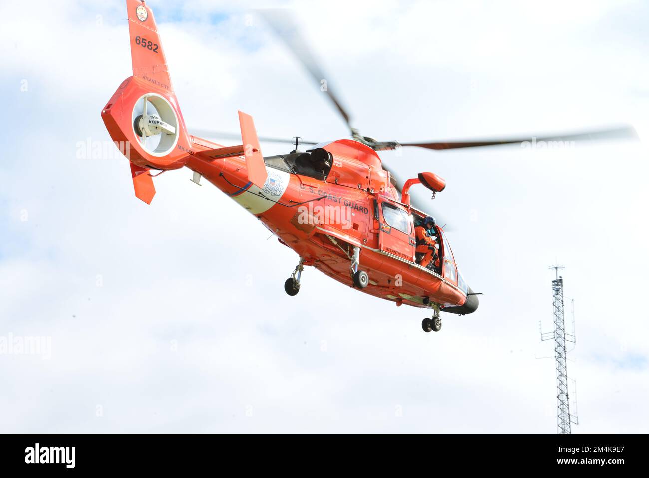 L'equipaggio dell'Air Station Atlantic City effettua operazioni in elicottero presso il Coast Guard Training Center di Cape May, New Jersey, per la storia del CBS Evening News. L'equipaggio conduce operazioni di addestramento in elicottero per rimanere pronto, pertinente e reattivo. (STATI UNITI Foto della Guardia Costiera di Petty Officer 3rd Classe Carmen Caver) Foto Stock