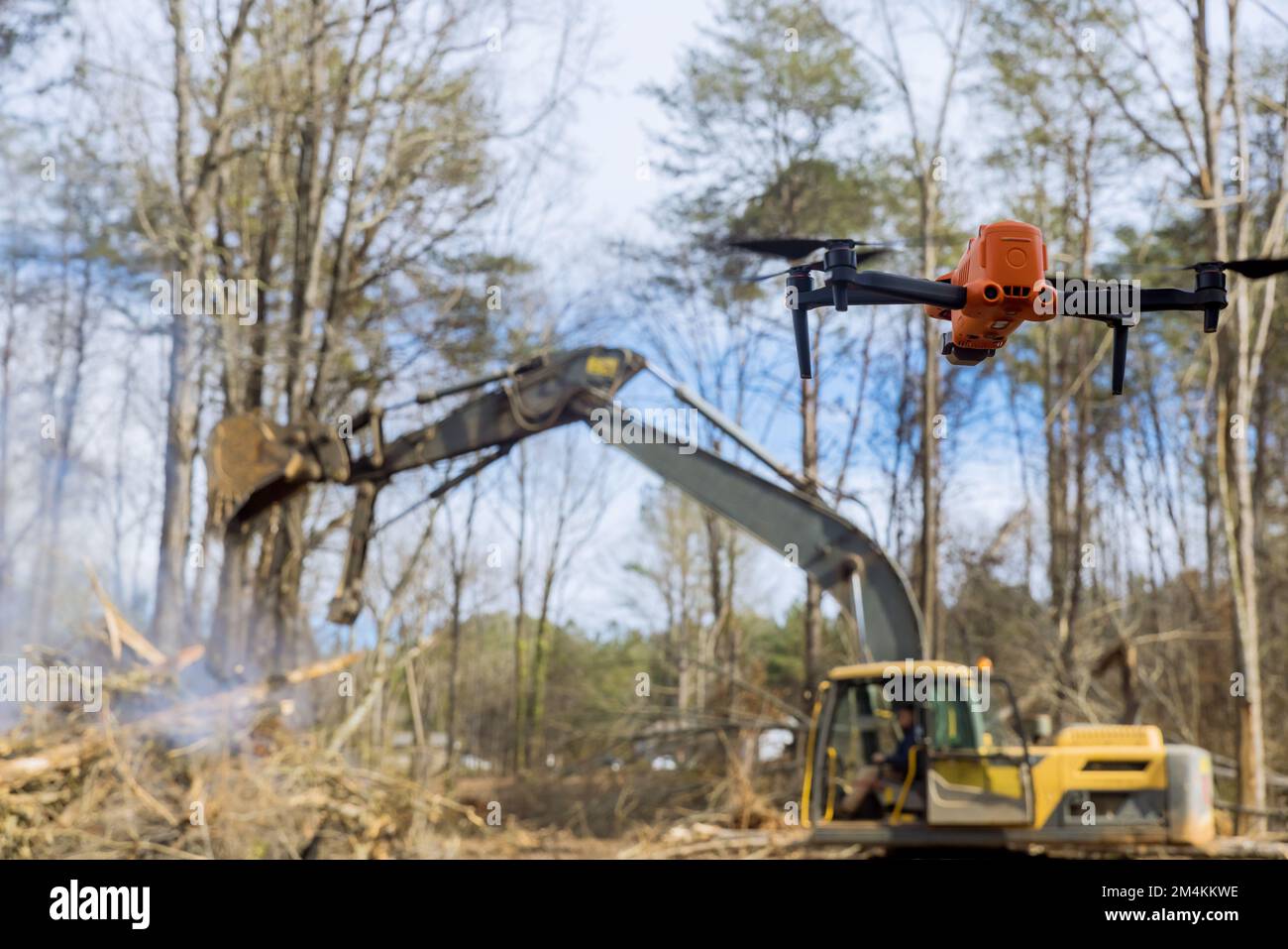 I droni vengono utilizzati dai vigili del fuoco per monitorare le bruciature controllate che sradica gli alberi nei cantieri Foto Stock