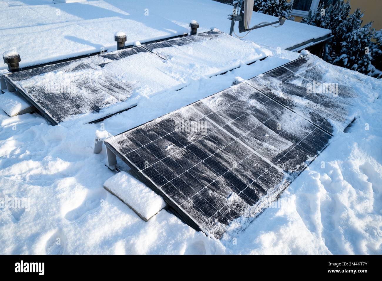 I pannelli solari sul tetto vengono puliti dalla neve con una scopa Foto Stock