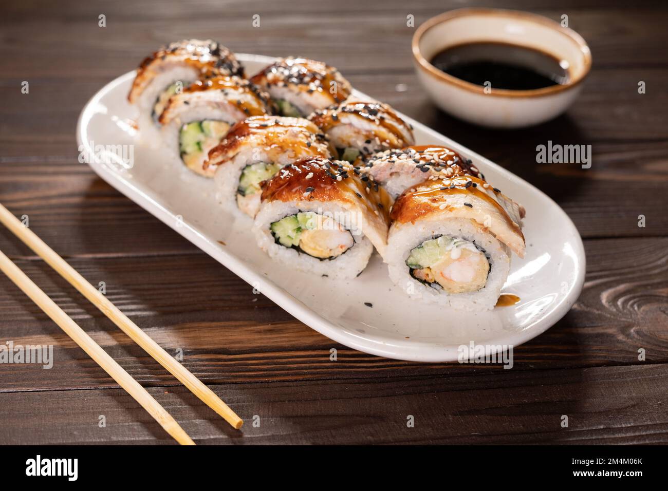 Cucina giapponese. Unagi Sushi Rolls su piatto con bacchette. Spazio di copia Foto Stock