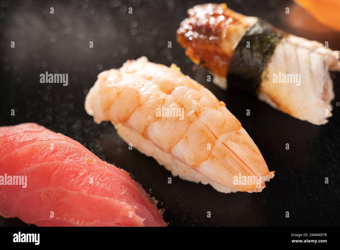 Sushi sashimi su sfondo nero, sushi nigiri di specialità di pesce su sfondo nero. Sushi di anguilla, salmone e tonno, menu del ristorante Foto Stock