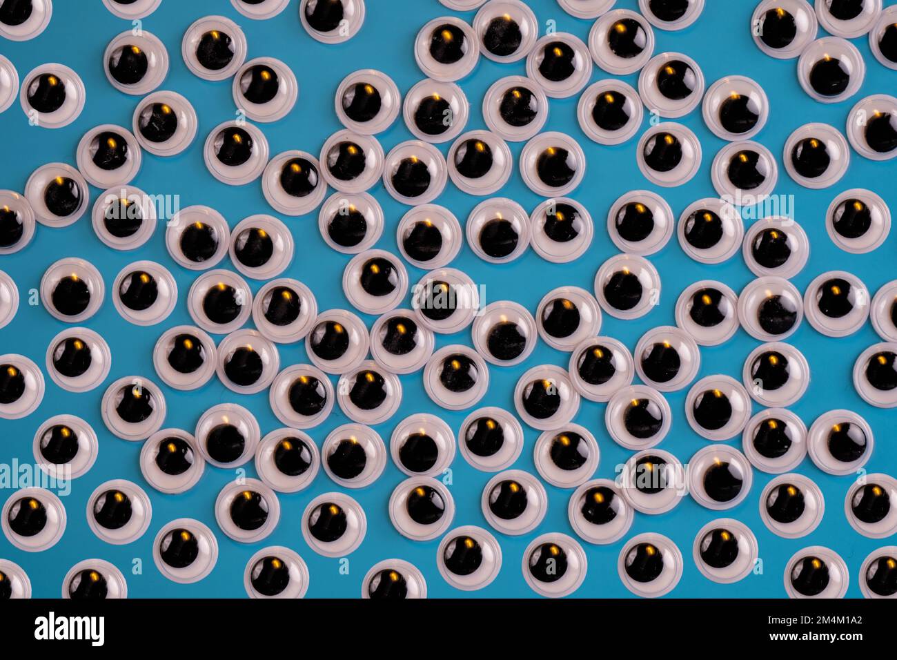 occhi bianchi neri googly isolati su uno sfondo blu Foto Stock