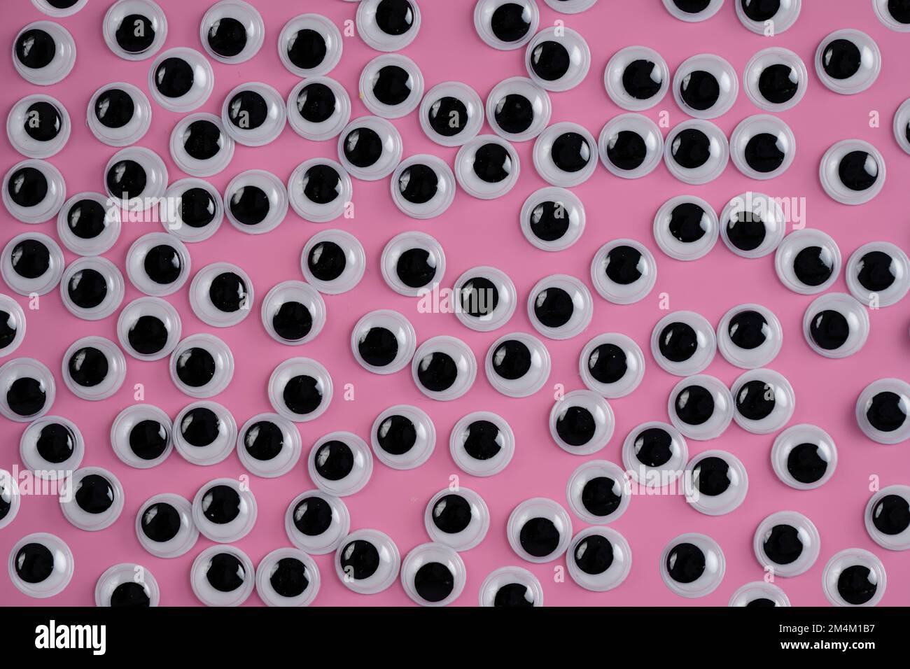 set di occhi bianchi neri googly isolati su uno sfondo rosa Foto Stock