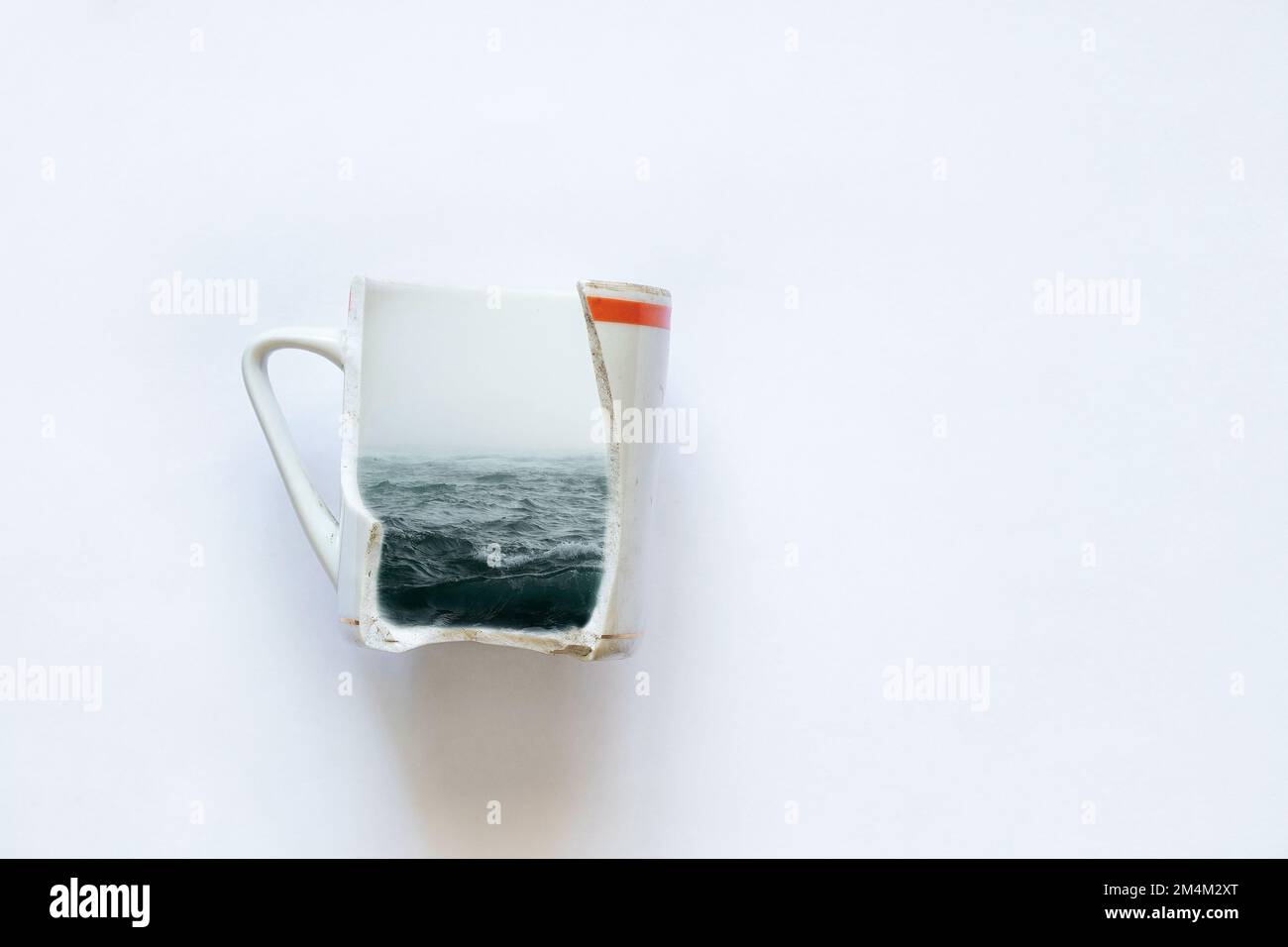 mare in una tazza rotta su uno sfondo bianco primo piano, sogni di mare, creatività Foto Stock