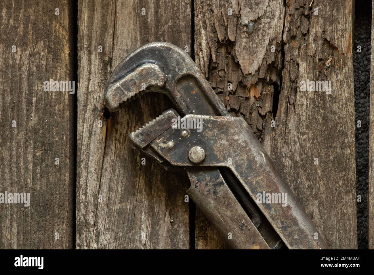 vecchia chiave a gas arrugginita si trova su un tavolo di legno primo piano Foto Stock