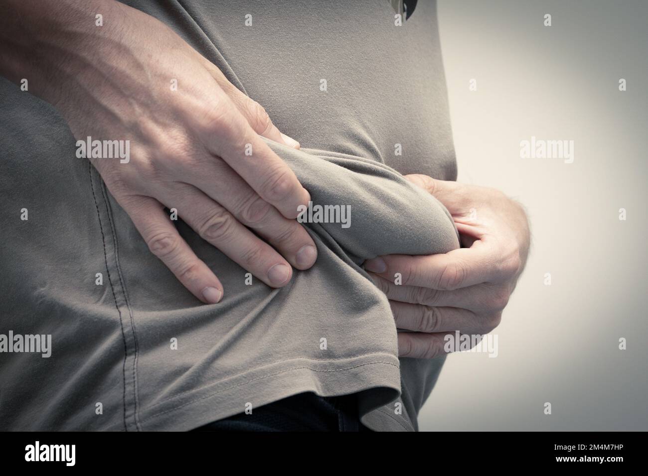 misurazione del grasso addominale in eccesso e del tessuto adiposo con un approccio plicometrico, concetto di immagine del corpo Foto Stock
