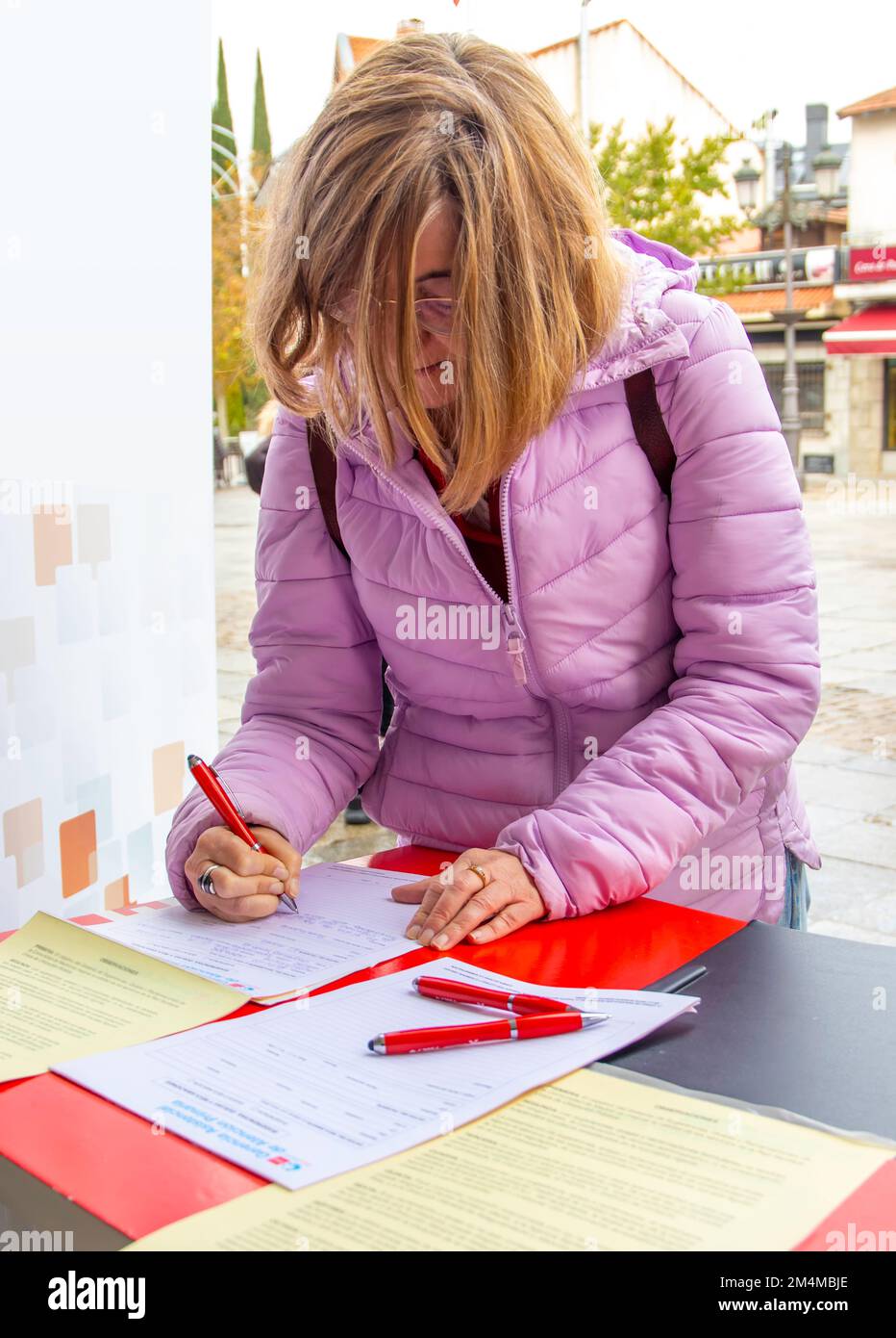 donna che compila un modulo sulla strada. Concetto di petizione della firma Foto Stock